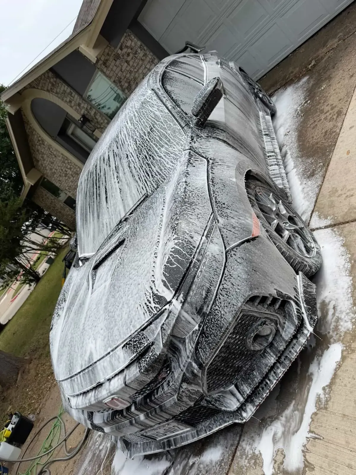 Vehicle covered in thick snow foam during a decontamination wash
